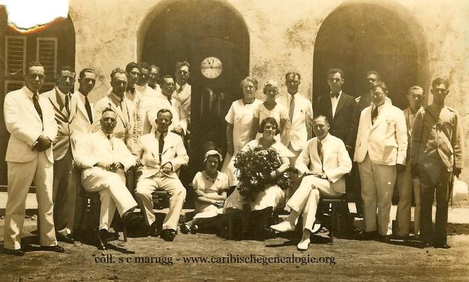 Ambstjubileum J.W.P. Peiliker (1893-1974) bij de Landsradiodienst op 25-08-1934. Peiliker (zittend 2de van links) dochter Zita Peiliker (midden op de grond), echtgenote Julia Peiliker-Jacobs (zittend 4de van links) en Louis C.H.M. Bergman (staand links naast het staand horloge). Foto: Collectie Louis (Manu) Bergman  